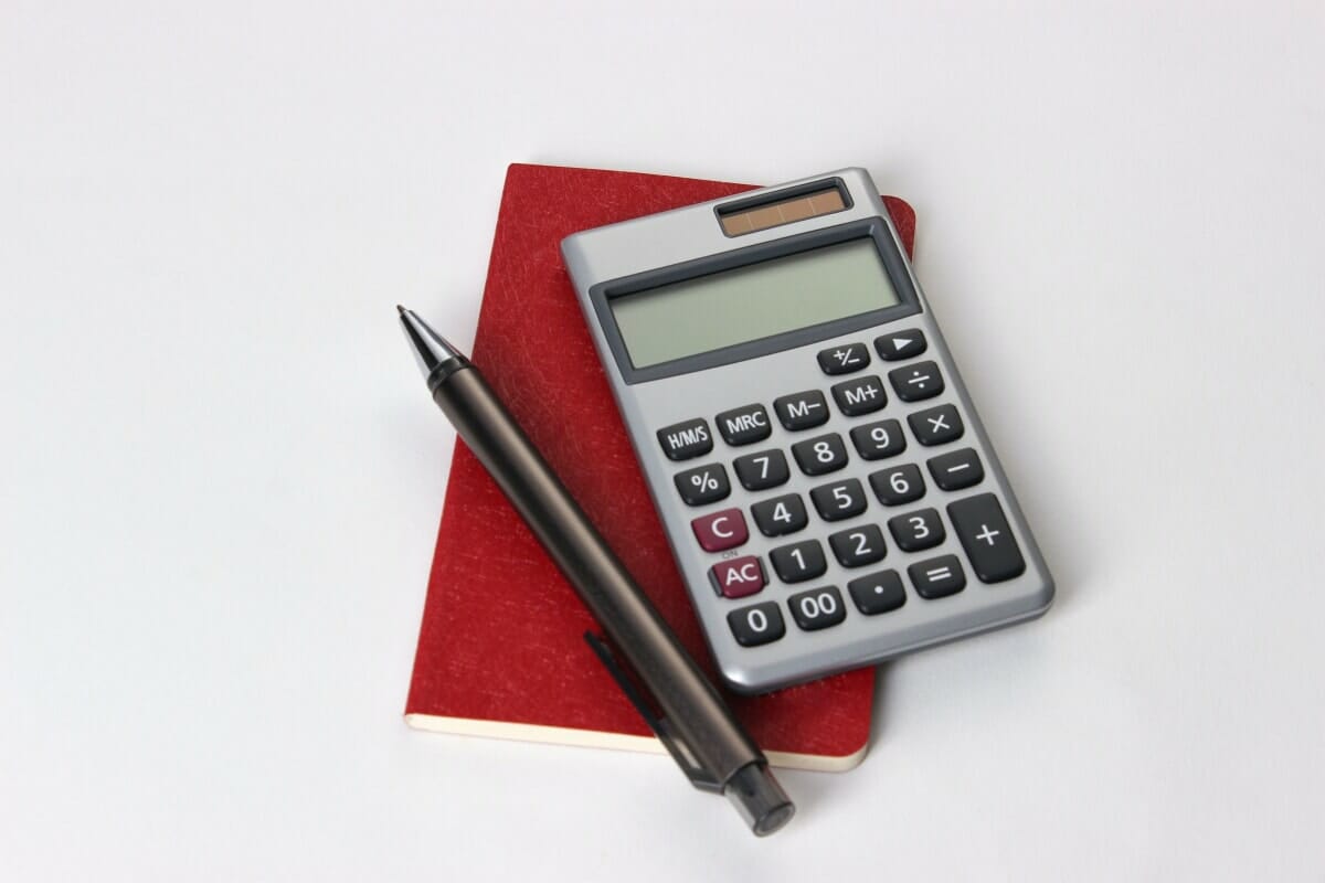 Calculator, pen, and folio representing the tools of a tax audit